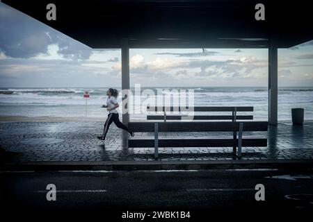 Tel Aviv, Israël. 11 janvier 2024. Un passant se promène le long de la promenade au bord de la Méditerranée tôt le matin. Crédit : Kay Nietfeld/dpa/Alamy Live News Banque D'Images