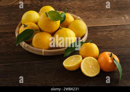 Fruits japonais yuzu posés sur une table en bois Banque D'Images