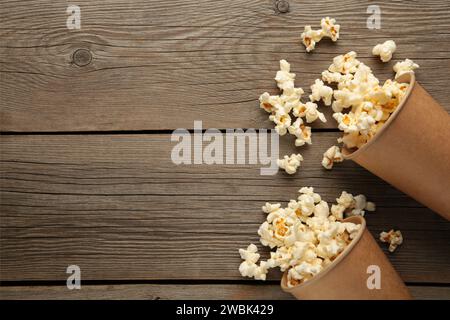 Pop-corn dans des tasses brunes. Deux tasses de pop-corn sur fond en bois gris. Pop-corn sucré. Vue de dessus Banque D'Images