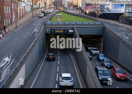 Voitures quittant le tunnel dans la zone d'air pur de 30 mph géré par le conseil municipal de Birmingham le long de l'A38 Queensway avec des voies de passage de l'A4400 Great Charles Street Queensway le 9 janvier 2024 à Birmingham, Royaume-Uni. La zone Air pur couvre la ville à l'intérieur du périphérique intérieur, mais n'inclut pas le Middleway lui-même. Une zone Air pur alias CAZ, est une zone dans certaines villes britanniques où des mesures ciblées sont prises pour améliorer la qualité de l'air. Un CAZ peut être sans charge ou en charge. La charge d'un véhicule lors de l'entrée ou du passage dans une ZAC dépend du type de véhicule. Véhicules à très faibles émissions Banque D'Images