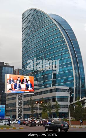 Grand écran montrant les nouvelles du soir à la télévision mongole sur la place Sukhbaatar en face de l'Hôtel Blue Sky, Oulan-Bator, Mongolie Banque D'Images