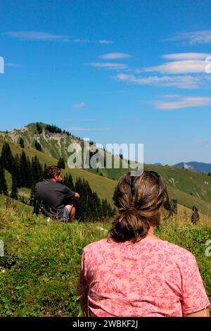 Homme et femme reposant à Gröbner Hals, Marbichler Spitze peut être vu en arrière-plan, Bächental, Eben am Achensee, Tyrol, Autriche Banque D'Images