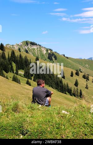 Homme reposant à Gröbner Hals, en arrière-plan vous pouvez voir le Marbichler Spitze, Bächental, Eben am Achensee, Tyrol, Autriche Banque D'Images