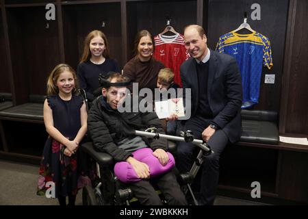 RETRANSMISSION AJOUTANT DES INFORMATIONS POUR LA LÉGENDE le prince de Galles (à droite) rencontre Rob Burrow, sa femme Lindsey Burrow et leurs enfants Maya (à gauche), Macy et Jackson lors d'une visite au stade Headingley, Leeds, pour le féliciter et lui décerner un Commandeur de l'ordre de l'Empire britannique (CBE) pour ses efforts de sensibilisation à la maladie neuronale motrice. Date de la photo : jeudi 11 janvier 2024. Banque D'Images