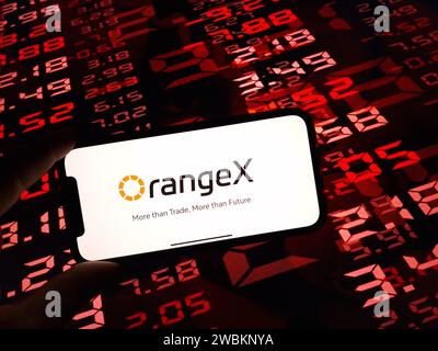 KONSKIE, Pologne - 05 janvier 2024 : logo d'échange de crypto-monnaie OrangeX affiché sur smartphone sur fond de données de marché crypto Banque D'Images