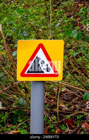 Panneau d'avertissement avec triangle rouge pour indiquer le danger de chute de pierres dans un endroit rural. Banque D'Images