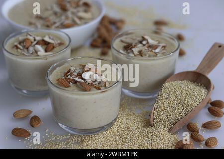 Délicieux Millet Proso Kheer dans un bol en verre, orné d'amandes croquantes, mettant en valeur un dessert nutritif. Autour du bol est un tas généreux o Banque D'Images