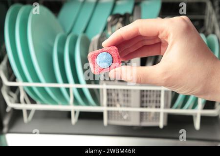 Tablette de lave-vaisselle en main sur le fond d'un lave-vaisselle ouvert. Vue de dessus Banque D'Images