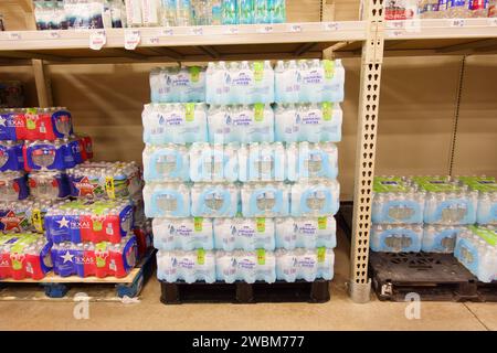 Paquets d'eau potable en bouteille sur palettes dans l'épicerie de supermarché Banque D'Images