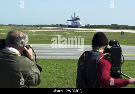 CENTRE SPATIAL KENNEDY, FLA. -- les médias (premier plan) capturent l'atterrissage de l'orbiteur Columbia au sommet d'un avion porte-navette. Le SCA et sa cargaison ont atterri sur la piste de glissement de la station aérienne de Cape Canaveral. Le vol en ferry a commencé en Californie le 1 mars. Des conditions météorologiques défavorables l'ont maintenu au sol à Dyess AFB, au Texas, jusqu'à ce qu'il puisse retourner en Floride. Columbia revient d'un processus de modification et de remise à neuf de 17 mois dans le cadre d'un plan d'entretien de routine. L’orbiteur volera ensuite sur la mission STS-107, prévue le 25 octobre Banque D'Images