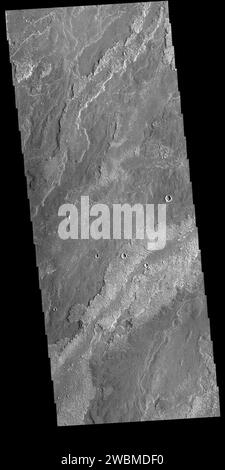 L'image vis d'aujourd'hui montre une partie des vastes coulées de lave qui composent Daedalia Planum. Ces coulées prennent leur source à Arsia Mons, le plus méridional des trois grands volcans alignés de la région de Tharsis sur Mars. Les différentes textures de surface se rapportent à des propriétés telles que la viscosité et la température de la lave fondue lorsqu’elle s’est écoulée puis refroidie en roche solide. Numéro d'orbite 81052 Latitude -21,9464 Longitude 238,195 instrument vis capturé 2020-03-23 03 13 Banque D'Images