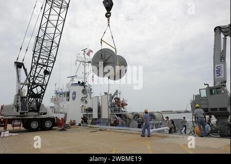 CAP CANAVERAL, Floride. – Une grue travaillant depuis le quai du Hangar AF à la Cape Canaveral Air Force Station en Floride enlève l'une des bobines retenant les parachutes et les lignes des boosters usés à droite du lancement final de la navette spatiale Atlantis. Les parachutes et le propulseur d'appoint ont été rassemblés par les équipages du Liberty Star, l'un des navires de récupération de propulseur d'appoint de la NASA. Les deux boîtiers de propulseur de fusée solide de la navette et le matériel de vol associé sont récupérés dans l'océan Atlantique après chaque lancement par Freedom Star et Liberty Star. Les boosters frappent l'Atlantique environ sept minutes après Banque D'Images