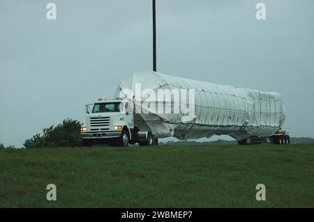 CENTRE SPATIAL KENNEDY, FLA. — Un camion transportant une roquette Atlas V s’éloigne de la bande de glissement de la station aérienne de Cape Canaveral. La fusée est en cours de transfert au Centre des opérations spatiales de l'Atlas. L’Atlas V est le lanceur du vaisseau spatial New Horizons. New Horizons est conçu pour nous aider à comprendre les mondes à la limite de notre système solaire en faisant la première reconnaissance de Pluton et Charon - une «planète double» et la dernière planète de notre système solaire à être visitée par des engins spatiaux. La mission visitera ensuite un ou plusieurs objets dans la région de la ceinture de Kuiper au-delà de Neptune. New Horizons i Banque D'Images