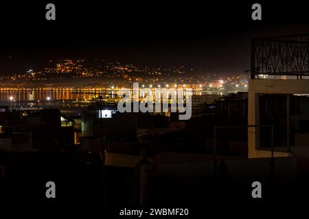 Tanger, Maroc. 15 octobre 2022 - vue de nuit sur la baie de Tanger, toits de maisons au centre de la médina, lumières de la côte de Malabata en arrière-plan Banque D'Images