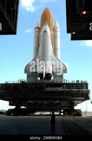 CENTRE SPATIAL KENNEDY, FLA. - Encadrée dans les portes ouvertes du Vehicle Assembly Building (VAB) du Kennedy Space Center de la NASA, la navette spatiale Discovery est baignée de lumière alors qu’elle entame son long et lent voyage jusqu’au Launch Pad 39B. La navette spatiale repose sur la plate-forme de lanceur mobile, qui est déplacée par le Crawler-transporter en dessous. Le Crawler mesure 20 pieds de haut, 131 pieds de long et 114 pieds de large. Il se déplace sur huit pistes, contenant chacune 57 chaussures, ou crampons, pesant une tonne chacune. Chargé de la navette spatiale, le Crawler peut se déplacer à une vitesse maximale d'environ 1 mile par heure. Un système de mise à niveau Banque D'Images