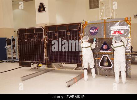 Les travailleurs de l'installation d'assemblage et d'encapsulation 2 (SAEF-2) apposent des logos sur les panneaux solaires Mars Odyssey, qui sont soumis à des tests d'illumination. L'orbiteur transportera trois instruments scientifiques, THEMIS, le spectromètre à rayons gamma (GRS) et l'expérience sur l'environnement de rayonnement de Mars (MARIE). THEMIS cartographiera la minéralogie et la morphologie de la surface martienne à l'aide d'une caméra haute résolution et d'un spectromètre infrarouge thermique. Le GRS réalisera une cartographie globale de la composition élémentaire de la surface et déterminera l'abondance d'hydrogène dans les sous-sols peu profonds Banque D'Images