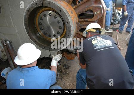 CENTRE SPATIAL KENNEDY, FLA. - Les ouvriers attachent le pignon géant et l'engrenage attaché au Crawler-transporter. Le pignon d'entraînement fait tourner le tapis sur le CT. Le pignon est couplé à l'engrenage qui se fixe au moteur d'entraînement. Le CT se déplace sur huit bandes de roulement à chenilles, chacune contenant 57 patins de bande de roulement, pour un poids combiné de 957 600 livres. Le CT transporte la navette spatiale au-dessus de sa plate-forme de lancement mobile, ajoutant 12 millions de livres supplémentaires, du bâtiment d'assemblage des véhicules à la plate-forme de lancement. Les ingénieurs du système CT de la NASA et de la United Space Alliance (USA) et les techniciens américains réparent le sp Banque D'Images