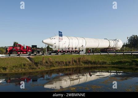 CAP CANAVERAL, Floride. – Un camion transporte un propulseur d’appoint de fusée solide de 149 pieds de long, ou SRB, à partir du complexe des visiteurs du Kennedy Space Center alors que l’attraction sur le thème spatial fait place à une nouvelle exposition mettant en vedette la navette spatiale Atlantis, qui est actuellement en préparation pour être exposée au public. Le SRB est placé en stockage temporaire au Kennedy Space Center de la NASA. Le SRB faisait partie d'une maquette du réservoir externe et de deux SRB au complexe des visiteurs qui ont été utilisés pour montrer aux visiteurs la taille des composants réels de la navette spatiale. Une navette spatiale a roulé dessus Banque D'Images