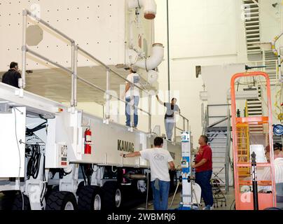 CENTRE SPATIAL KENNEDY, FLA. - Les travailleurs de l'installation de rotation de canister au Kennedy Space Center de la NASA observent le canister de charge utile après sa rotation vers une position verticale. Le bidon sera transporté jusqu'à la plate-forme de lancement 39B. Les charges utiles à l’intérieur, y compris le module logistique polyvalent Raffaello et la plate-forme de rangement externe-2, seront déplacées dans la salle de changement de charge utile dans la structure de service rotative, puis installées dans la baie de charge utile de Discovery. Le lancement de la navette spatiale Discovery est prévu lors de la mission de retour en vol STS-114 vers la Station spatiale internationale. La fenêtre de lancement e Banque D'Images