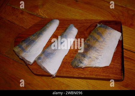 Filets de viande de poisson Zander sur une planche de bois Banque D'Images