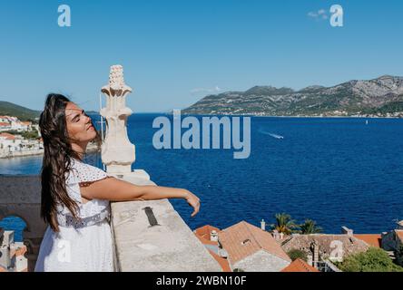 Une jeune femme séduisante portant une élégante robe blanche pose une prise de vue captivante Banque D'Images