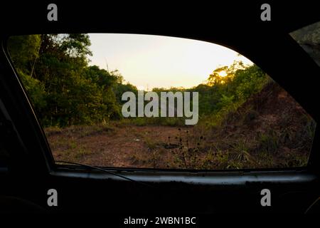Un sentier dans la forêt amazonienne à travers une voiture abandonnée Banque D'Images