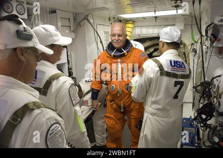 CAP CANAVERAL, Floride. – Dans la salle blanche sur la plateforme de lancement 39a du Kennedy Space Center de la NASA en Floride, John Phillips, spécialiste de mission STS-119, est aidé par l’équipage de fermeture qui met son harnais, qui comprend un sac de parachute, avant de ramper à travers la trappe ouverte dans la navette spatiale Discovery. La White Room se trouve à l'extrémité du bras d'accès de l'orbiteur sur la structure de service fixe et permet d'accéder à la navette. La mission STS-119 est la 28e à la Station spatiale internationale et le 125e vol de la navette spatiale. Discovery livrera la dernière paire de panneaux solaires générateurs d'énergie wi Banque D'Images