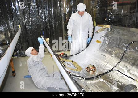 BASE AÉRIENNE DE VANDENBERG, CALIFORNIE -- les techniciens à l'intérieur du bâtiment 1555 effectuent l'inspection, le nettoyage et les essais électriques sur la moitié d'un carénage de charge utile pour orbital Sciences Corp. Fusée Pegasus XL qui lancera le vaisseau spatial interface Region Imaging Spectrograph, ou IRIS. Le carénage sera monté sur le nez du Pegasus pour protéger le vaisseau spatial de la chaleur atmosphérique et des contraintes pendant le lancement. IRIS ouvrira une nouvelle fenêtre de découverte en retraçant le flux d’énergie et de plasma à travers les chromosphères et la région de transition dans la couronne solaire à l’aide de la spectrométrie et de l’imagerie. IRIS Banque D'Images