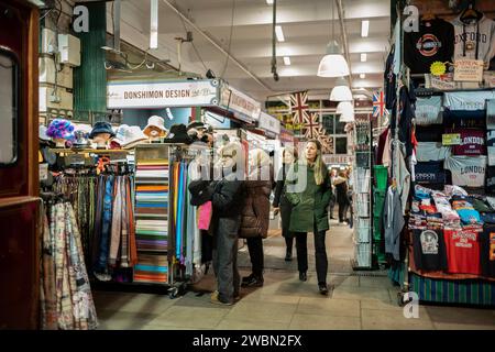 Touristes parcourant des articles sur des stands à l'intérieur de Jubilee Market, construit en 1904, Tavistock Street, Covent Garden, centre de Londres, Angleterre, Royaume-Uni Banque D'Images