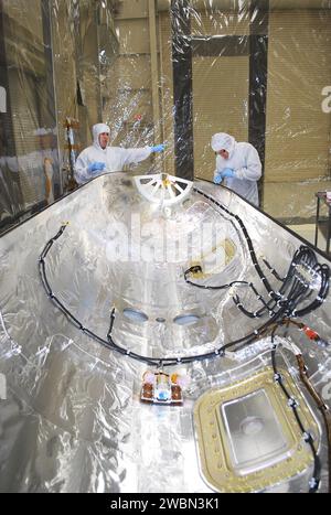 BASE AÉRIENNE DE VANDENBERG, CALIFORNIE -- les techniciens à l'intérieur du bâtiment 1555 effectuent l'inspection, le nettoyage et les essais électriques sur la moitié d'un carénage de charge utile pour orbital Sciences Corp. Fusée Pegasus XL qui lancera le vaisseau spatial interface Region Imaging Spectrograph, ou IRIS. Le carénage sera monté sur le nez du Pegasus pour protéger le vaisseau spatial de la chaleur atmosphérique et des contraintes pendant le lancement. IRIS ouvrira une nouvelle fenêtre de découverte en retraçant le flux d’énergie et de plasma à travers les chromosphères et la région de transition dans la couronne solaire à l’aide de la spectrométrie et de l’imagerie. IRIS Banque D'Images