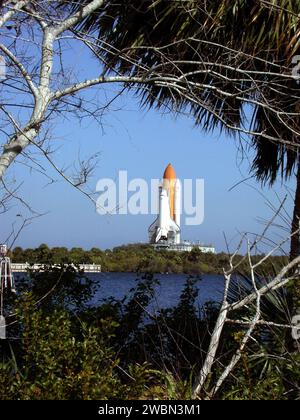 CENTRE SPATIAL KENNEDY, FLA. -- la navette spatiale Atlantis est encadrée par des palmiers et des branches dénudées d'hiver alors qu'elle se fraie un chemin de Launch Pad 39a vers le bâtiment d'assemblage de véhicules. Atlantis revient au VAB afin que les travailleurs puissent effectuer des inspections, effectuer des vérifications de continuité et effectuer des analyses aux rayons X sur les 36 câbles de démarrage de fusée solide situés à l’intérieur du tunnel du système de chaque propulseur. Une évaluation approfondie de l’inventaire de câbles SRB de la NASA a révélé des dommages causés aux conducteurs dans quatre (sur environ 200) câbles sur l’étagère. Les gestionnaires de navettes ont décidé de prouver l'intégrité des câbles du tunnel du système déjà installés Banque D'Images