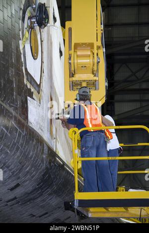 Dans le bâtiment d'assemblage de véhicules de la NASA au Kennedy Space Center, les techniciens attachent une grue à la navette spatiale s'efforcent de la soulever en position pour la connexion avec son réservoir de carburant externe et ses propulseurs de fusée solide, préparant la mission STS-134. Banque D'Images