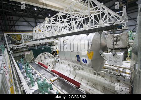 CAP CANAVERAL, Floride. -- dans l'Orbiter Processing Facility-2 (OPF-2) du Kennedy Space Center de la NASA en Floride, les techniciens surveillent les progrès réalisés lorsqu'un dispositif spécial de retrait de la charge utile soulève le module logistique polyvalent Raffaello de la soute de cargaison d'Atlantis. Raffaello sera ensuite préparé pour être transporté à l'installation de traitement de la station spatiale où son contenu sera déchargé. Atlantis a terminé la dernière mission de navette spatiale de la NASA, STS-135, après avoir atterri au centre d’atterrissage de la navette, le 21 juillet 2011, à 5:57 h HAE. Après le retrait de toutes les charges utiles dans la soute de cargaison d’Atlantis, les travailleurs le feront Banque D'Images