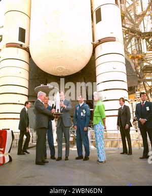 CENTRE SPATIAL KENNEDY, FLA. -- le vice-président George H. W. Bush, au centre, flanqué des astronautes Robert L. Crippen à sa droite et John W. Young à sa gauche, reçoit une maquette de la navette spatiale du Dr Alan M. Lovelace, administrateur intérimaire de la National Aeronautics and Space Administration. À l'extrême droite se trouve Mme Bush, qui a accompagné le vice-président lors de sa tournée éclair du véhicule de la navette et des installations de lancement. En arrière-plan, on trouve les parties arrière de l'orbiteur, le char externe et les propulseurs de fusée à solide. La navette, le premier système de transport spatial réutilisable des États-Unis, est prévue Banque D'Images