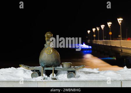 Sur le quai de Kolobrzeg, « Marian », une sculpture de mouette, se dresse gracieusement au milieu d'une nuit d'hiver enchantée. La jetée enneigée renforce le b serein Banque D'Images