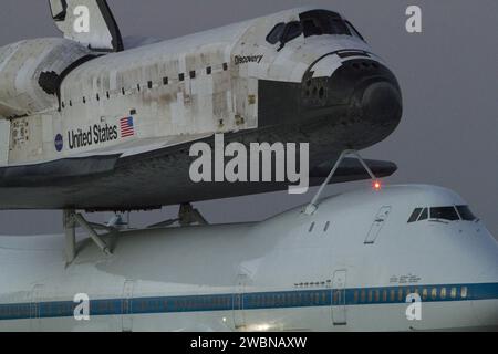 CAP CANAVERAL, Floride. - La navette spatiale Discovery est fixée au sommet de l'avion porte-navette en prévision d'un décollage matinal du Kennedy Space Center de la NASA en Floride. Le duo a quitté la piste 15 de Kennedy à 7 h HAE. L'avion, connu sous le nom de SCA, est un Boeing 747, fabriqué à l'origine pour un usage commercial, qui a été modifié par la NASA pour transporter les navettes entre des destinations sur Terre. Ce SCA, désigné NASA 905, est affecté aux missions de traversier restantes, livrant les navettes à leurs sites d'exposition publique permanente. NASA 905 a transporté Discovery à la Wa Banque D'Images