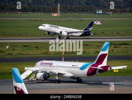 Aéroport de Düsseldorf, Lufthansa Airbus sur la piste, Eurowings Airbus en position parking Banque D'Images