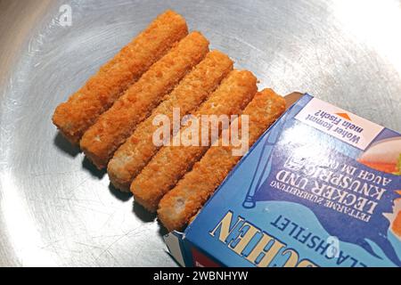 Fisch als Lebensmittel Fischstäbchen liegen während der Zubereitung in einer Edelstahlpfanne *** poisson comme aliment les doigts de poisson sont placés dans une poêle en acier inoxydable pendant la préparation Banque D'Images