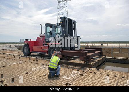 CAP CANAVERAL, Floride. – Au Launch Pad 39B du Kennedy Space Center de la NASA en Floride, un ouvrier du bâtiment prépare un panneau de chenille sur la surface du pad pour le retrait. La surface en béton sous les panneaux et le toit de catacombe ci-dessous seront inspectés pour détecter les dommages causés par l'eau et réparés. Il y a 176 panneaux, chacun pesant environ 30 000 livres qui seront enlevés. Le Launch Pad 39B est en cours de rénovation pour supporter le système de lancement spatial de la NASA et d’autres lanceurs. Le bureau du programme Ground Systems Development and Operations, ou GSDO, à Kennedy, dirige la transformation du centre vers une ha sûre Banque D'Images