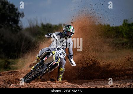 Pilote de motocross en action avec vitesse à la caméra et soulever la boue, les roches et la saleté. Banque D'Images