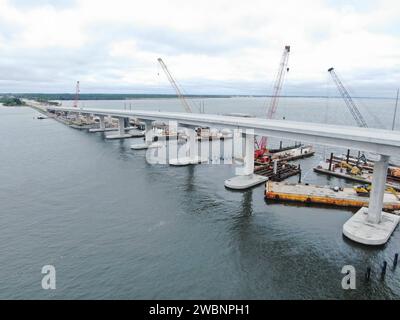 Dans cette vue aérienne, les équipages d’Orion Marine Construction travaillent à compléter la travée en direction ouest du pont Indian River, tandis que le trafic quotidien se déplace le long des voies améliorées en direction est du pont menant au Kennedy Space Center de la NASA en Floride le lundi 27 novembre 2023. Le pont traverse la lagune de la rivière Indian et relie Kennedy et la station spatiale Cape Canaveral au continent via State Road 405/NASA Causeway à Titusville. Le nouveau pont de grande hauteur sert d'entrée et de sortie principale au centre spatial pour les employés et les visiteurs. Les nouvelles travées de pont remplacent une paire o Banque D'Images