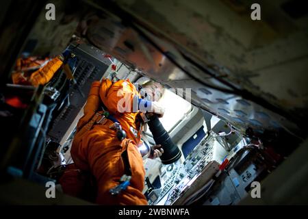 L'astronaute de la NASA Sandy Magnus, spécialiste de la mission STS-135, pratique l'utilisation d'un appareil photo numérique avec un long téléobjectif alors qu'elle participe à une séance de formation post-insertion dans le Full-fuselage Trainer dans le Space Vehicle Mock-up Facility du Johnson Space Center de la NASA le jeudi 24 mars 2011 à Houston. ( NASA photo / Houston Chronicle, Smiley N. Pool ) Banque D'Images