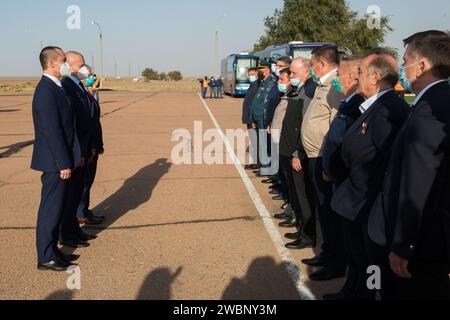 Les membres de l'équipage de secours de l'expédition 64 le cosmonaute russe Petr Dubrov de Roscosmos, à gauche, le cosmonaute russe Oleg Novitskiy de Roscosmos, au centre, et l'astronaute de la NASA Mark Vande Hei, saluent les officiels russes après leur arrivée à Baïkonour, au Kazakhstan, depuis le Centre d'entraînement des cosmonautes Gagarines, le dimanche 27 septembre 2020. L'équipage principal devrait se lancer du cosmodrome de Baïkonour à bord d'une fusée Soyouz le 14 octobre. Banque D'Images