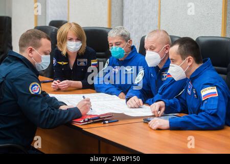 Les membres de l'équipage de secours de l'expédition 64, Mark Vande Hei, astronaute de la NASA, à gauche, et les cosmonautes russes Oleg Novitskiy, au centre, et Petr Dubrov, à droite, de Roscosmos, examinent les procédures de lancement avec des entraîneurs, mardi 6 octobre 2020, à l'hôtel Cosmonaut de Baïkonour, Kazakhstan. Les membres de l'équipage principal de l'expédition 64 Sergey Ryzhikov de Roscosmos, Sergey Kud-Sverchkov de Roscosmos, et Kate Rubins de la NASA, devraient se lancer vers la Station spatiale internationale à bord du vaisseau spatial Soyouz MS-17 le 14 octobre. Banque D'Images