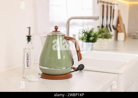 Nettoyage de la bouilloire électrique. Bouteille de vinaigre et bicarbonate de soude sur le comptoir dans la cuisine Banque D'Images