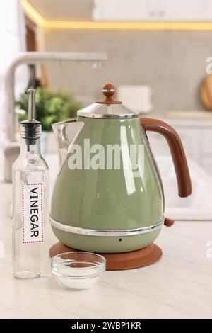 Nettoyage de la bouilloire électrique. Bouteille de vinaigre et bicarbonate de soude sur le comptoir dans la cuisine Banque D'Images