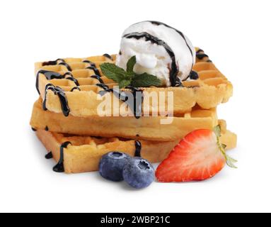 Gaufres belges savoureuses avec crème glacée, baies et sirop de chocolat sur fond blanc Banque D'Images