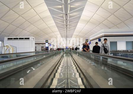 Passagers sur un escalier roulant automatique à l'aéroport international de Hong Kong， Chine Banque D'Images