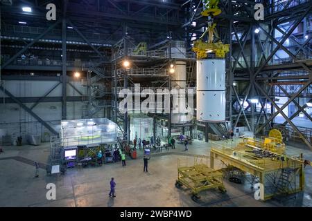 Dans High Bay 4 du Vehicle Assembly Building du Kennedy Space Center de la NASA en Floride, une grue déplace des segments de lanceur de fusée solide SLS (Space Launch System) pour les empiler sur d’autres segments de lanceur au cours d’un exercice d’entraînement le 8 janvier 2020. Une équipe d’ingénieurs d’exploration Ground Systems et d’opérateurs de grues et de techniciens avec l’entrepreneur Jacobs pratiquent des manœuvres de levage, de déplacement et d’empilage, en utilisant de l’équipement de soutien au sol important pour former les employés et certifier que tout l’équipement fonctionne correctement. Les pathfinders de booster sont des répliques inertes à grande échelle du réel Banque D'Images