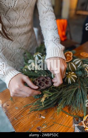 Une jeune femme participe à un atelier d'artisanat, fabriquant des ornements de Noël festifs. Banque D'Images